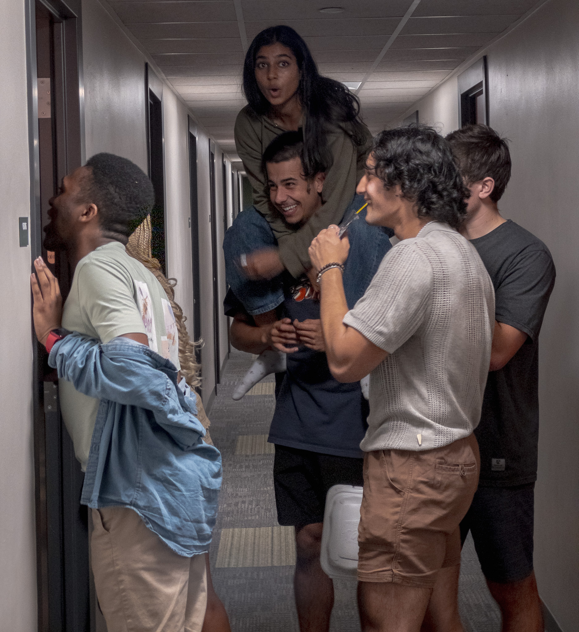 students leaning into doorframe talking