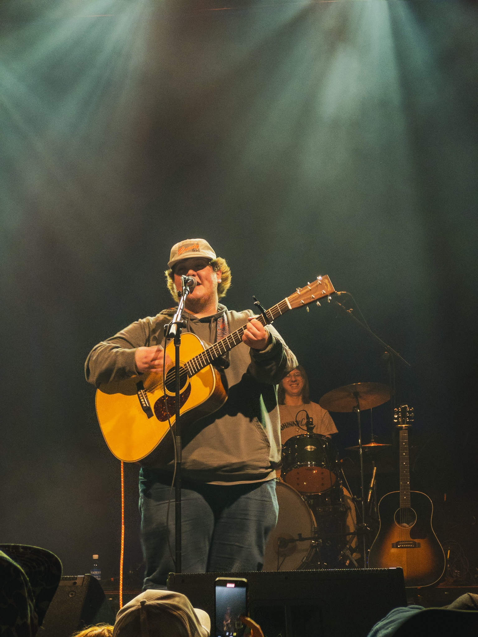 man in center plays guitar and sings