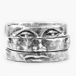 A silver ring made made of three stacked rings that form a face