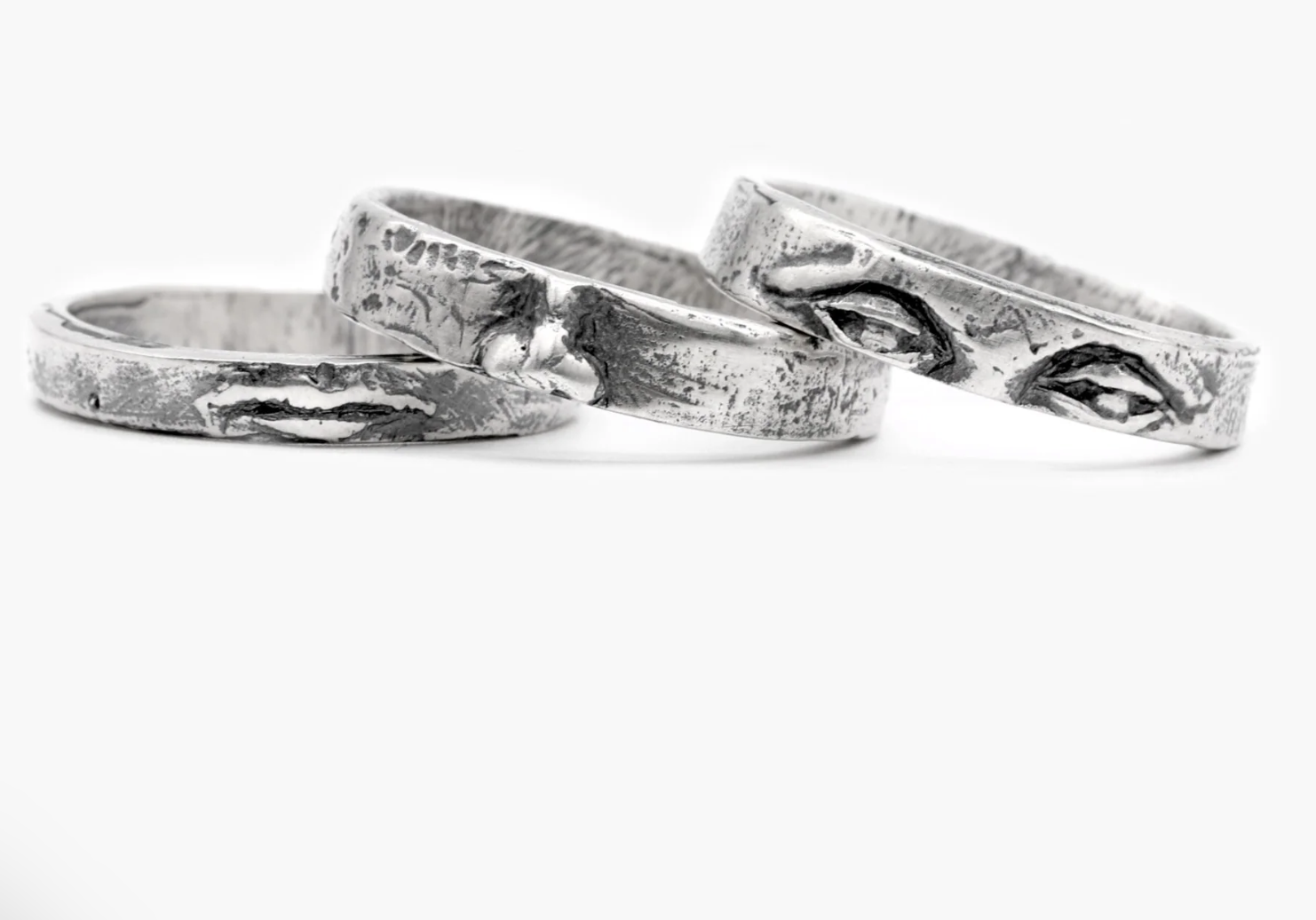 A stack of silver rings spread out that looks like a face