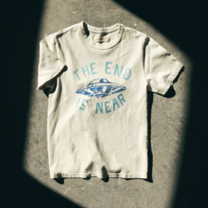 dramatically lit image of a t-shirt that reads "The End Is Near" with a UFO in the center