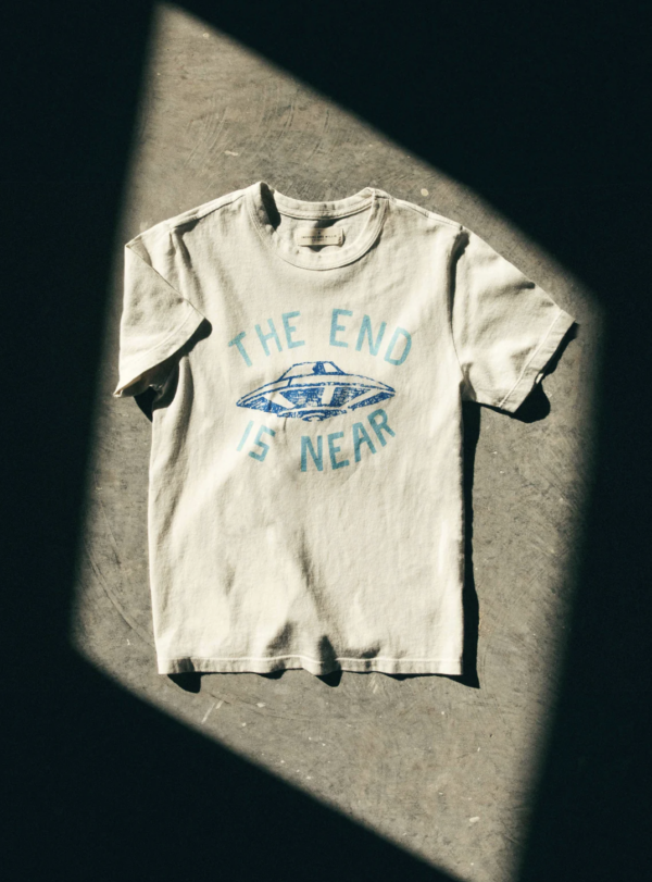 dramatically lit image of a t-shirt that reads "The End Is Near" with a UFO in the center