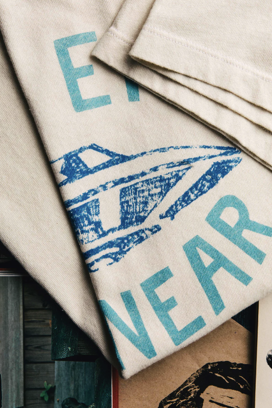 Close up of white t-shirt that says "The End Is Near" in blue text with a UFO in the center showing a quality fabric
