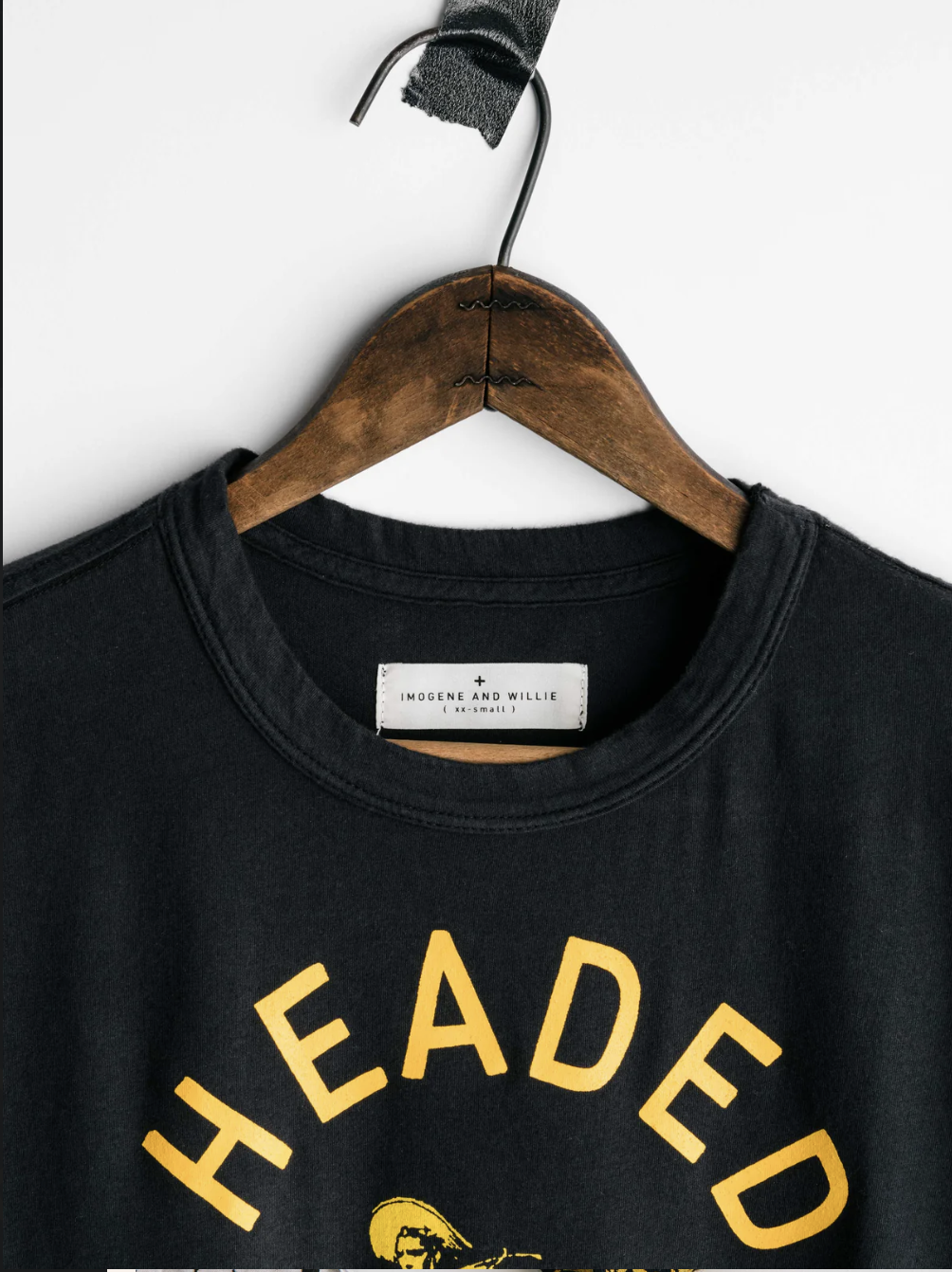 close up of product tag on black shirt that says headed nowhere with cowboy