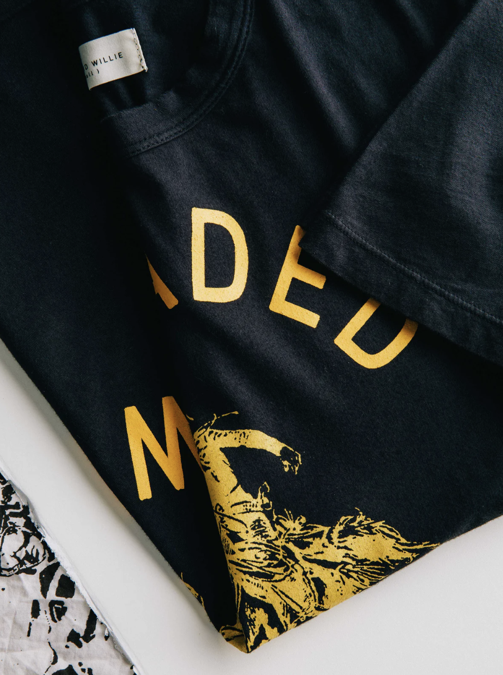 close up of black shirt with words that cannot be read. Shows quality fabric